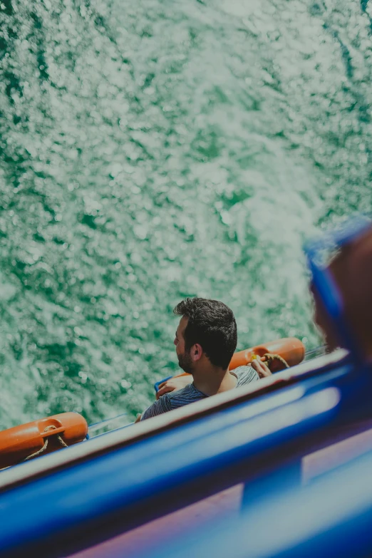 a man sitting in an orange boat with two lifejackets attached