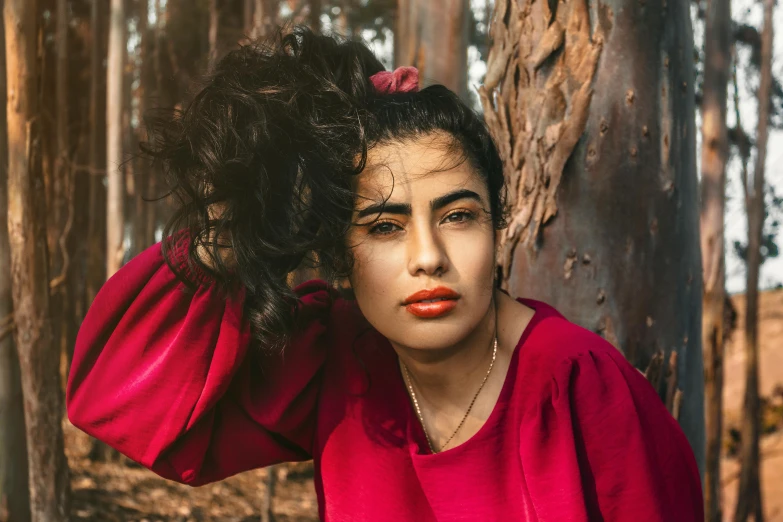 a woman wearing a red top in the woods