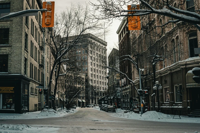 a snow covered road and many building with traffic lights