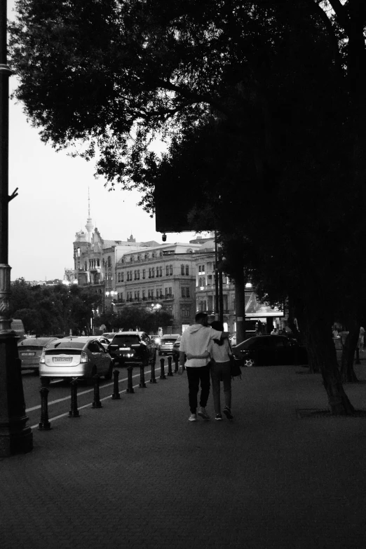 people are walking down the sidewalk in front of some buildings