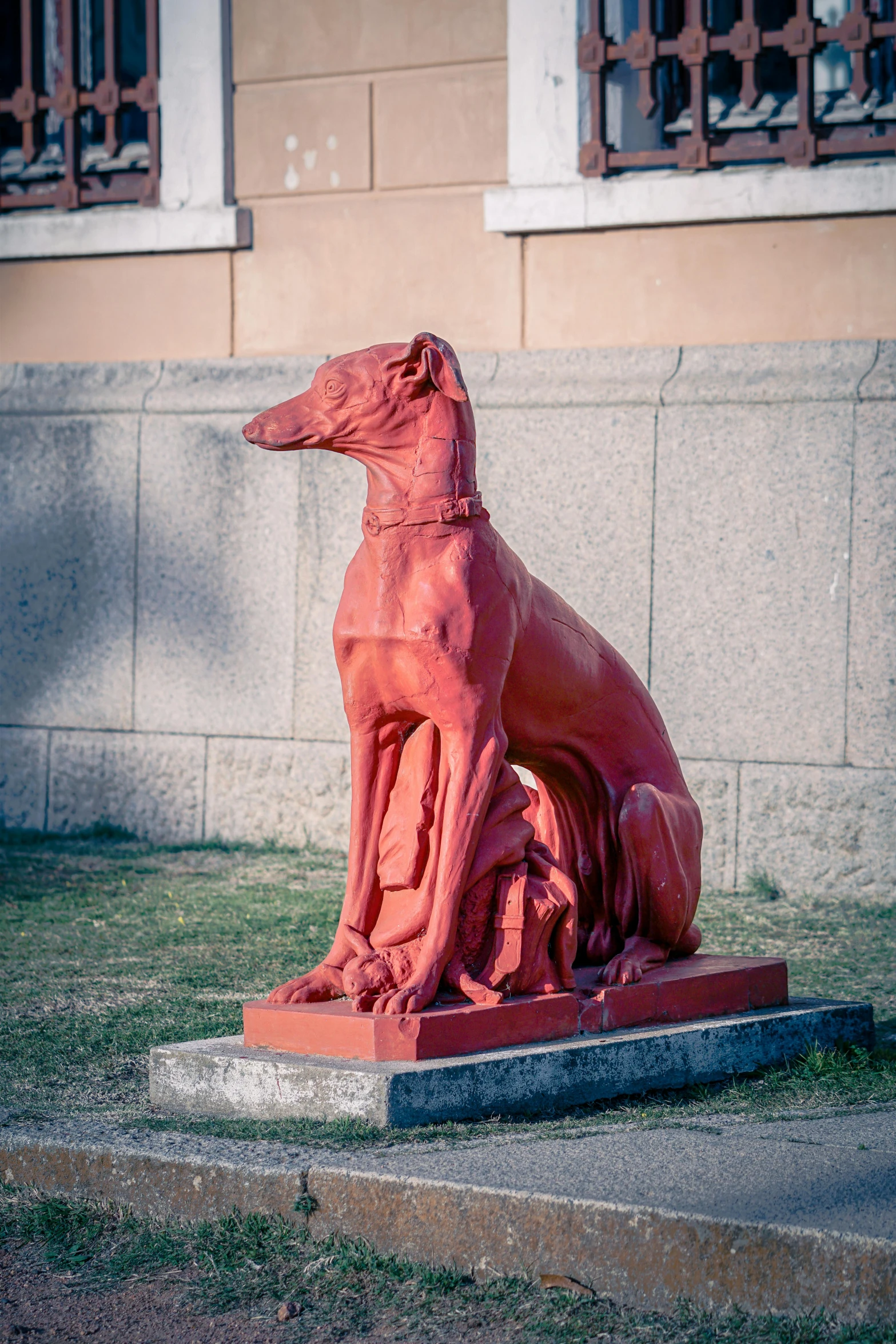 a pink statue sitting in front of a wall