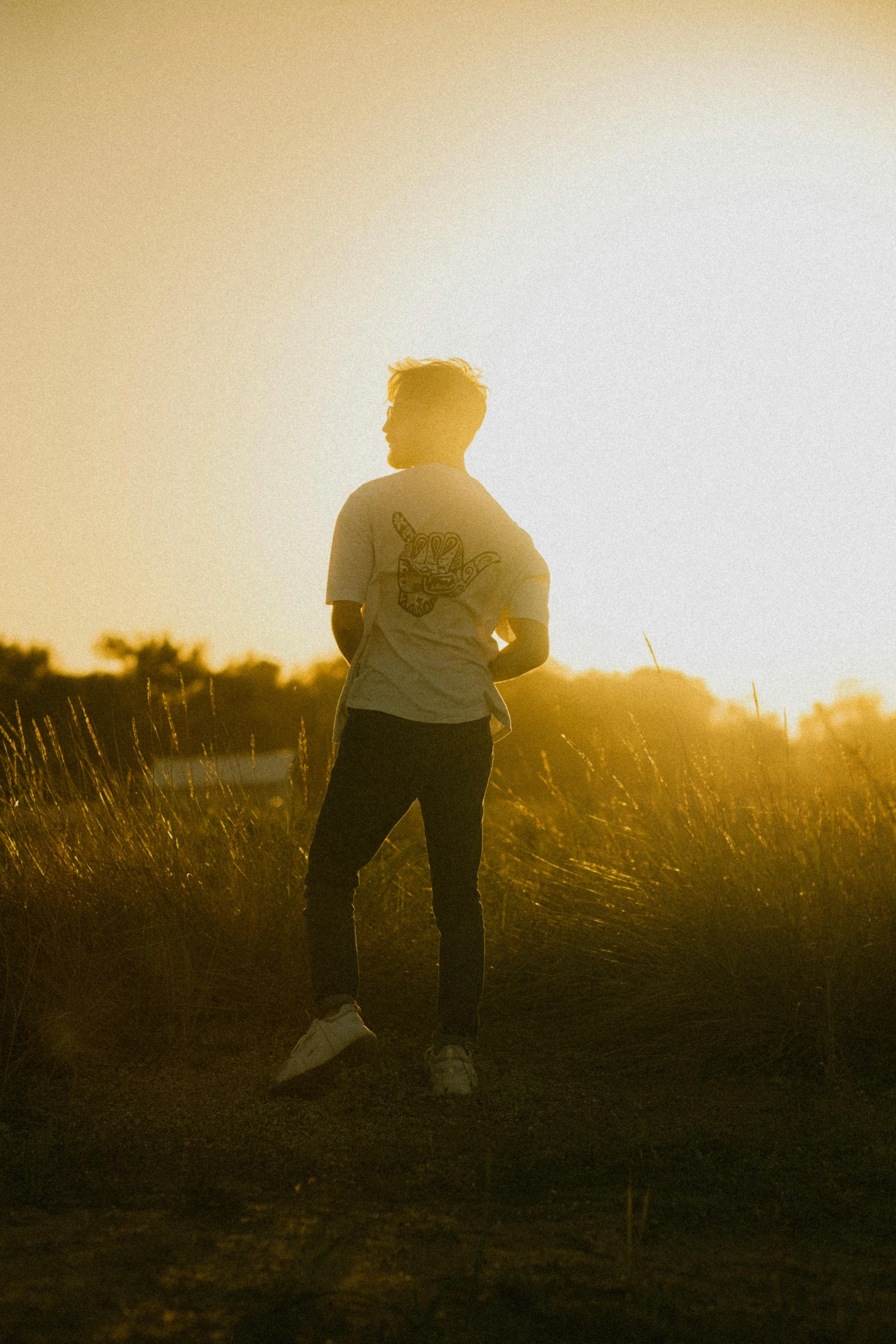 the sun is setting behind the man in the field