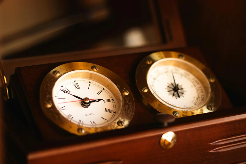 two clocks sit on the shelf of a chest