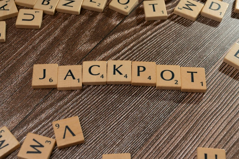 several scrabble tiles spelling out the word jackpot and all letters are spelled by them