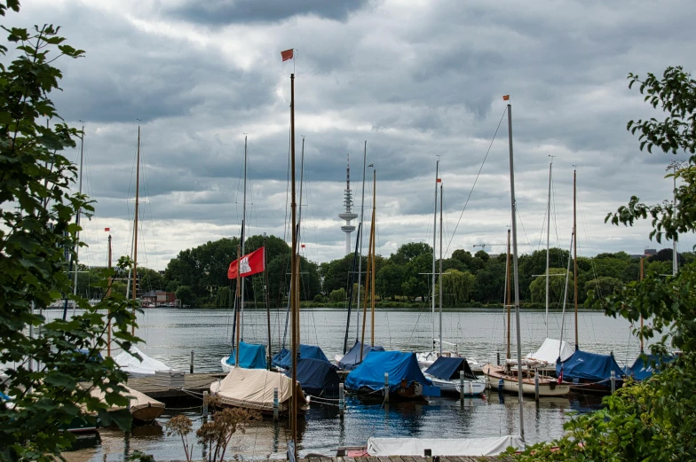 several sail boats moored in the harbor under a dark sky