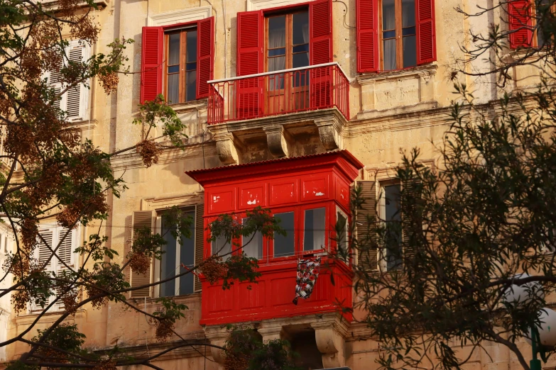 an old building with red shutters and shuttered windows