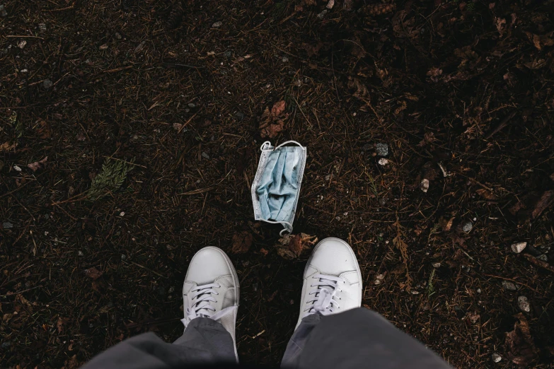 someone standing next to a leaf filled ground