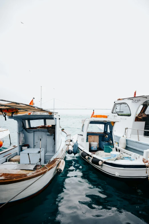 three small white boats are tied to the docks