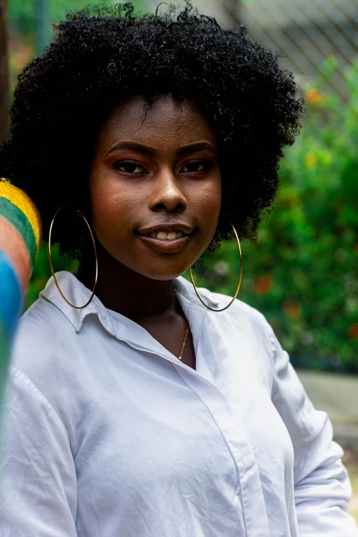 an african american woman with curly hair wearing a pair of earrings