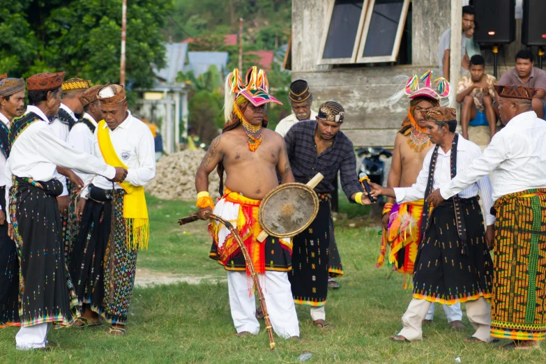 men in colorful dress perform different tribal dances