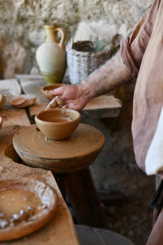 a person is spinning a bowl on a potter's wheel