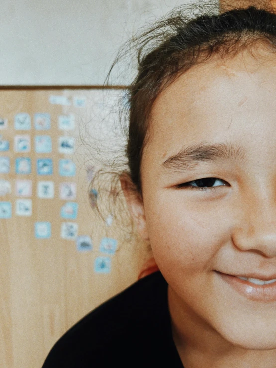 a little girl smiling with a cell phone next to her