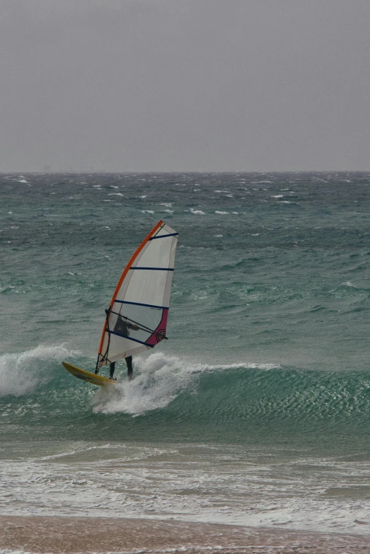 a person wind surfing on a big wave