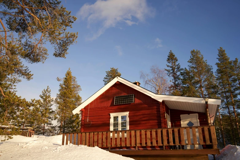 a cabin in a snowy forest with trees in the background