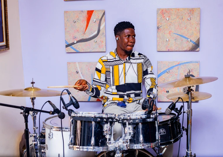 a young man playing a drum set in his living room