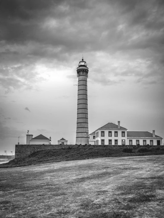 a lighthouse on the shore during a cloudy day