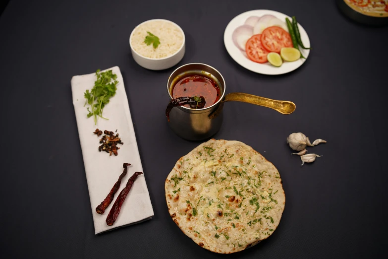 various food dishes with spoons and a small tin