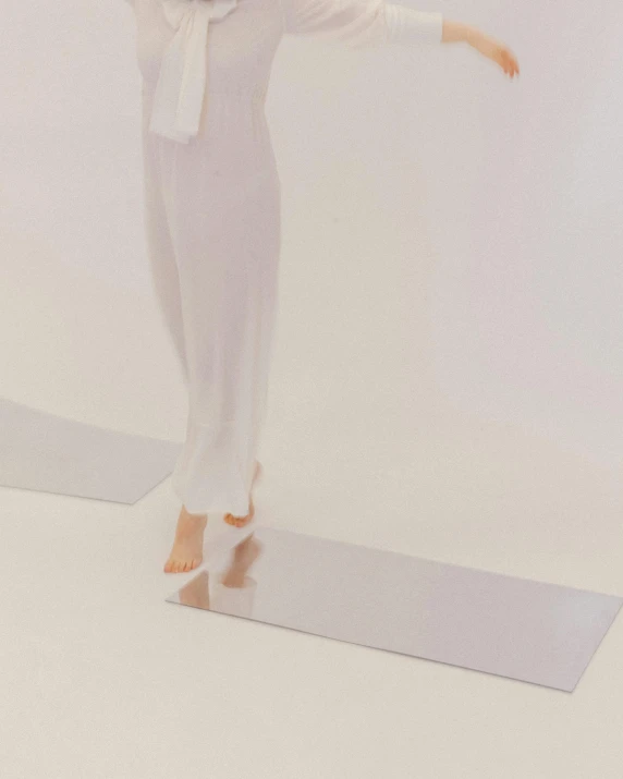 a woman stands on top of a mat in the white room
