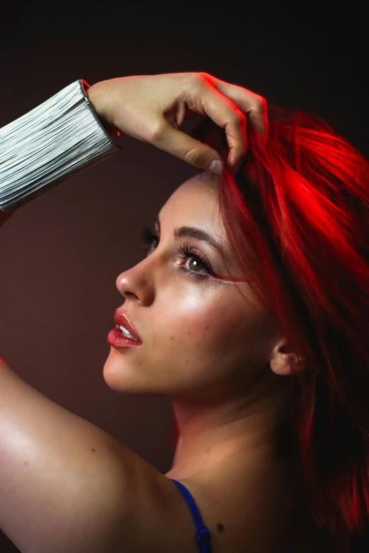 a woman with long red hair is wearing silver jewelry