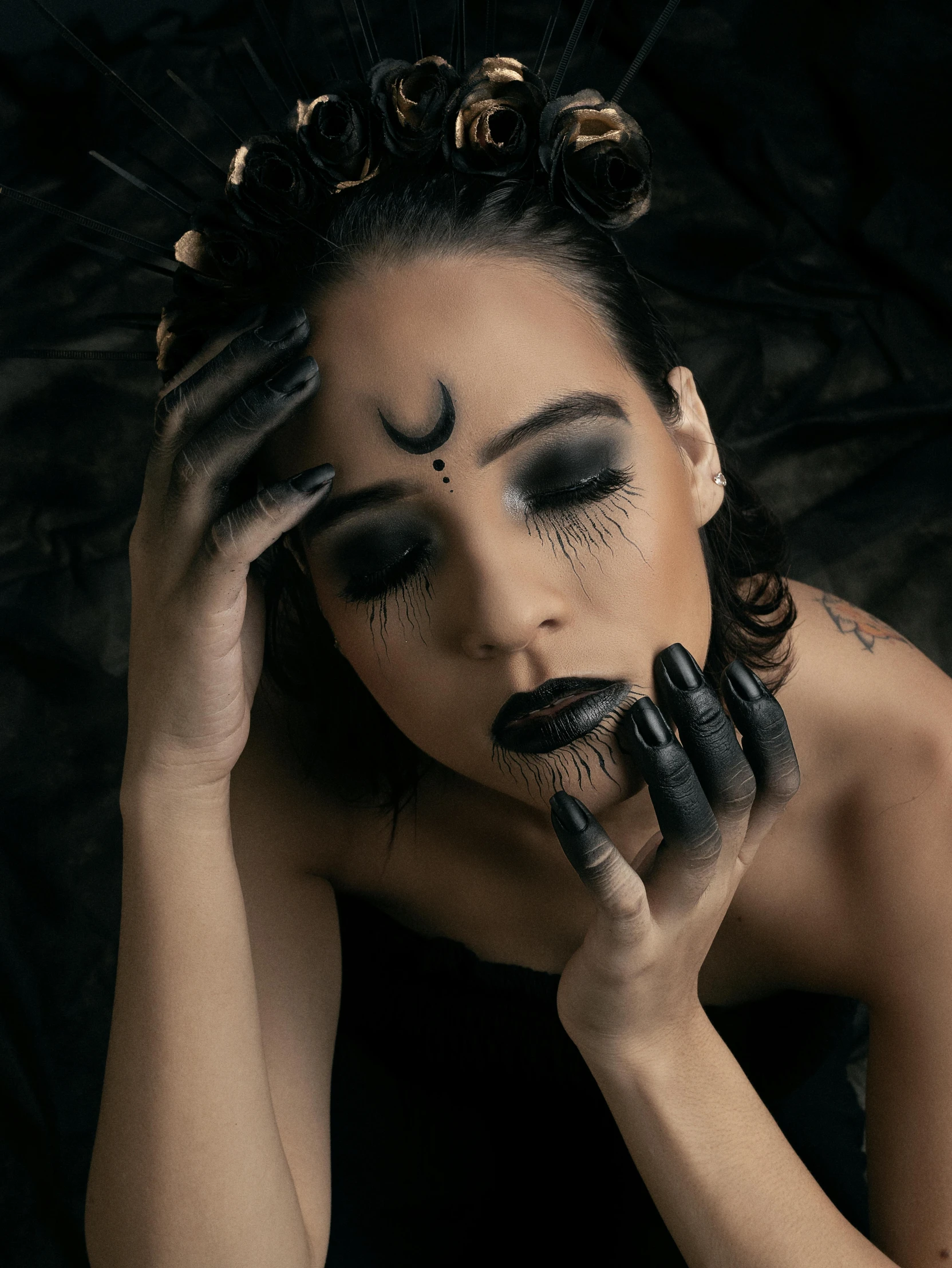 a person wearing black makeup posing for the camera