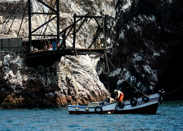 a boat sailing down a river under a bridge