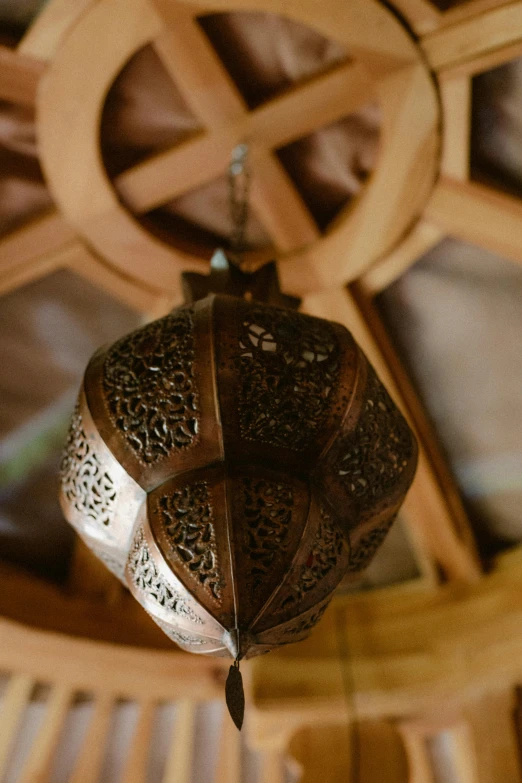 a small metal lantern sitting inside of a wooden chandelier