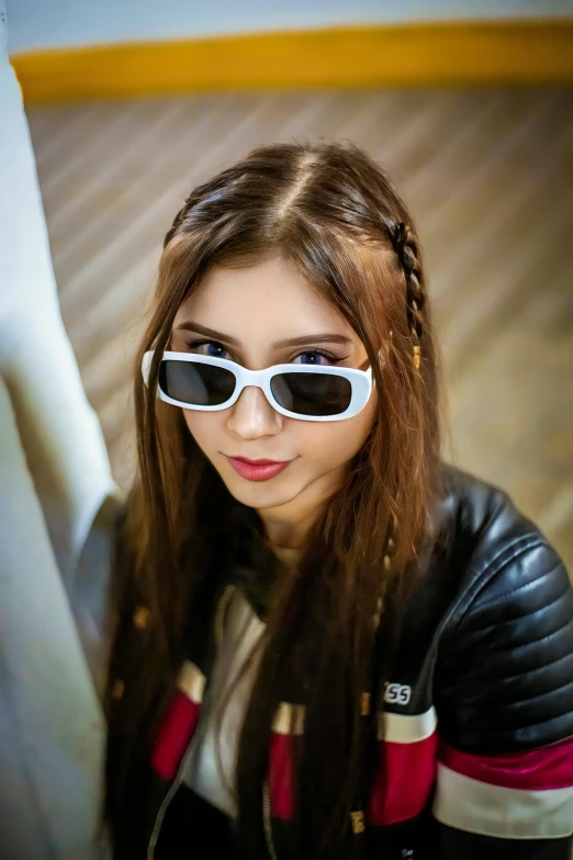 a girl in white sunglasses wearing a black jacket and striped top