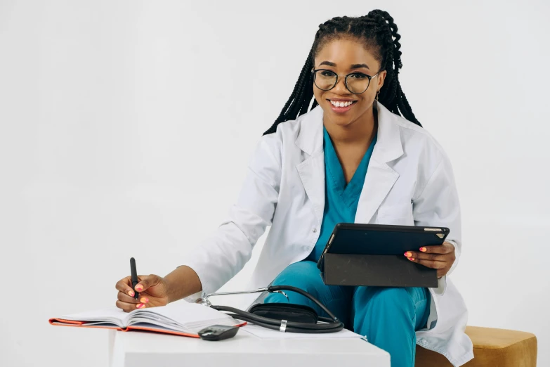 the doctor has a binder on her knee and holds a pen and notebook