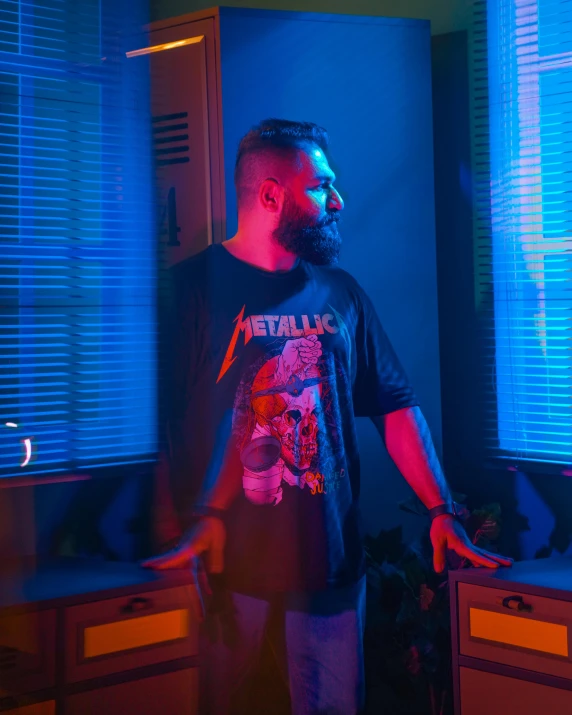 a man stands by the counter in front of a window with blue lights