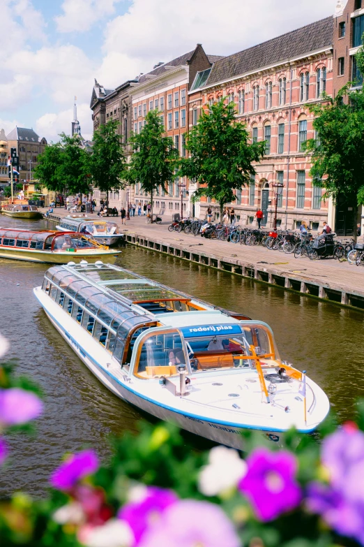 many boats floating down a river near large buildings