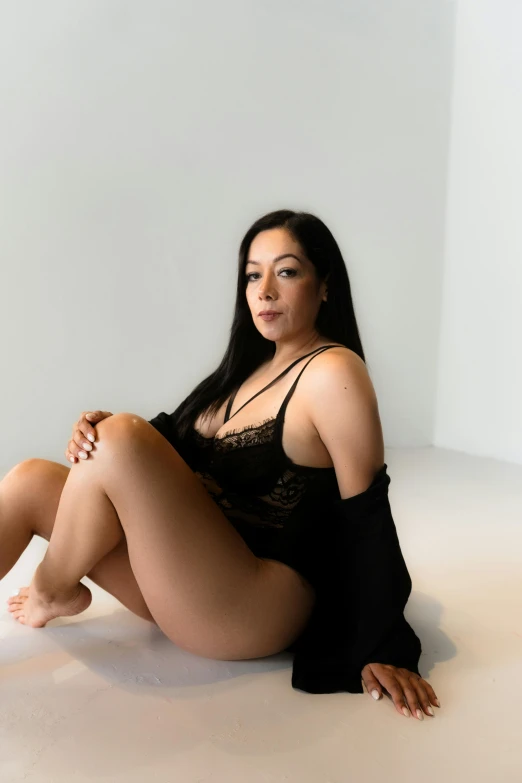 a woman in black lingerie is sitting down