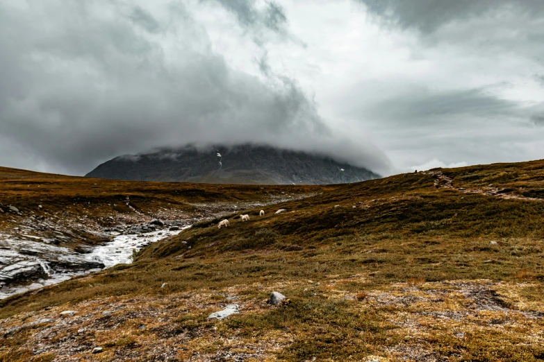 the hills are covered with snow under a stormy sky