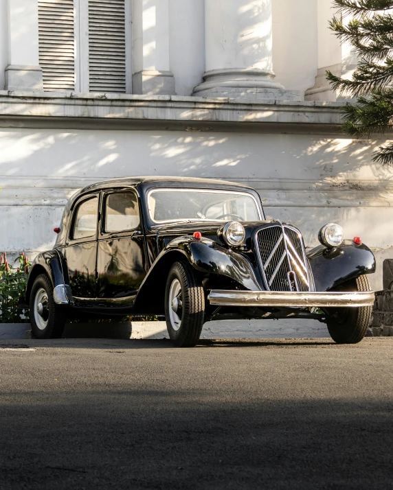 an old fashion black car parked in front of a building