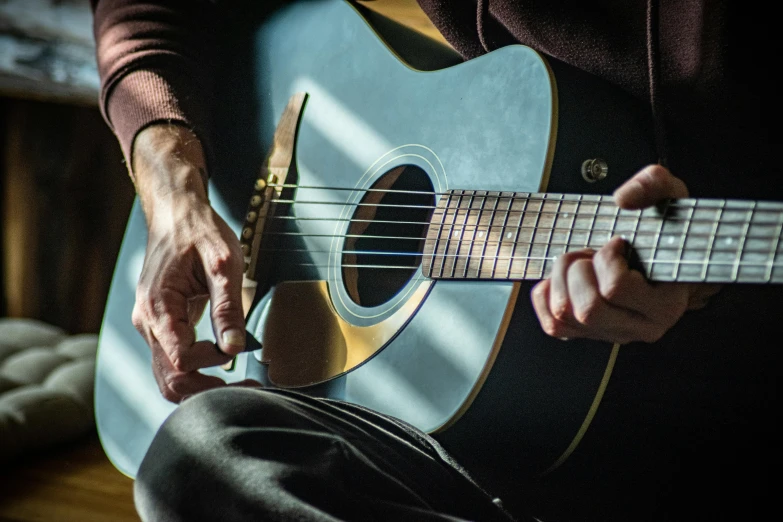 person playing an acoustic guitar in the dark