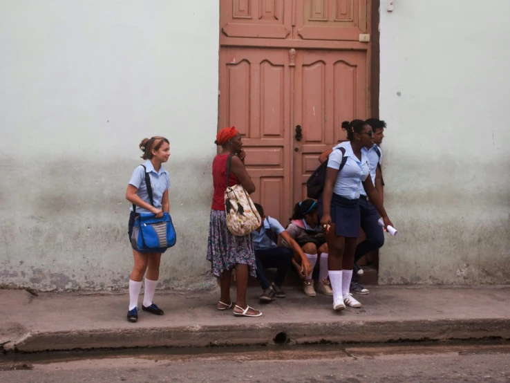 four girls are standing in front of a doorway