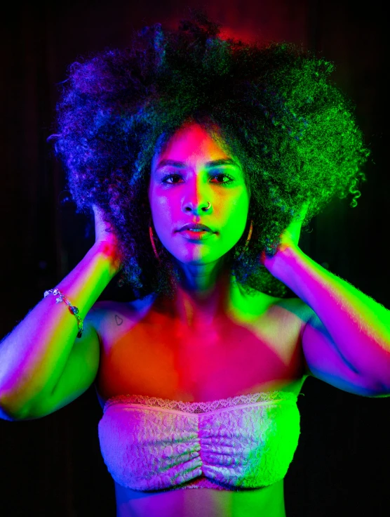 a young woman with dark skin and neon - colored lighting