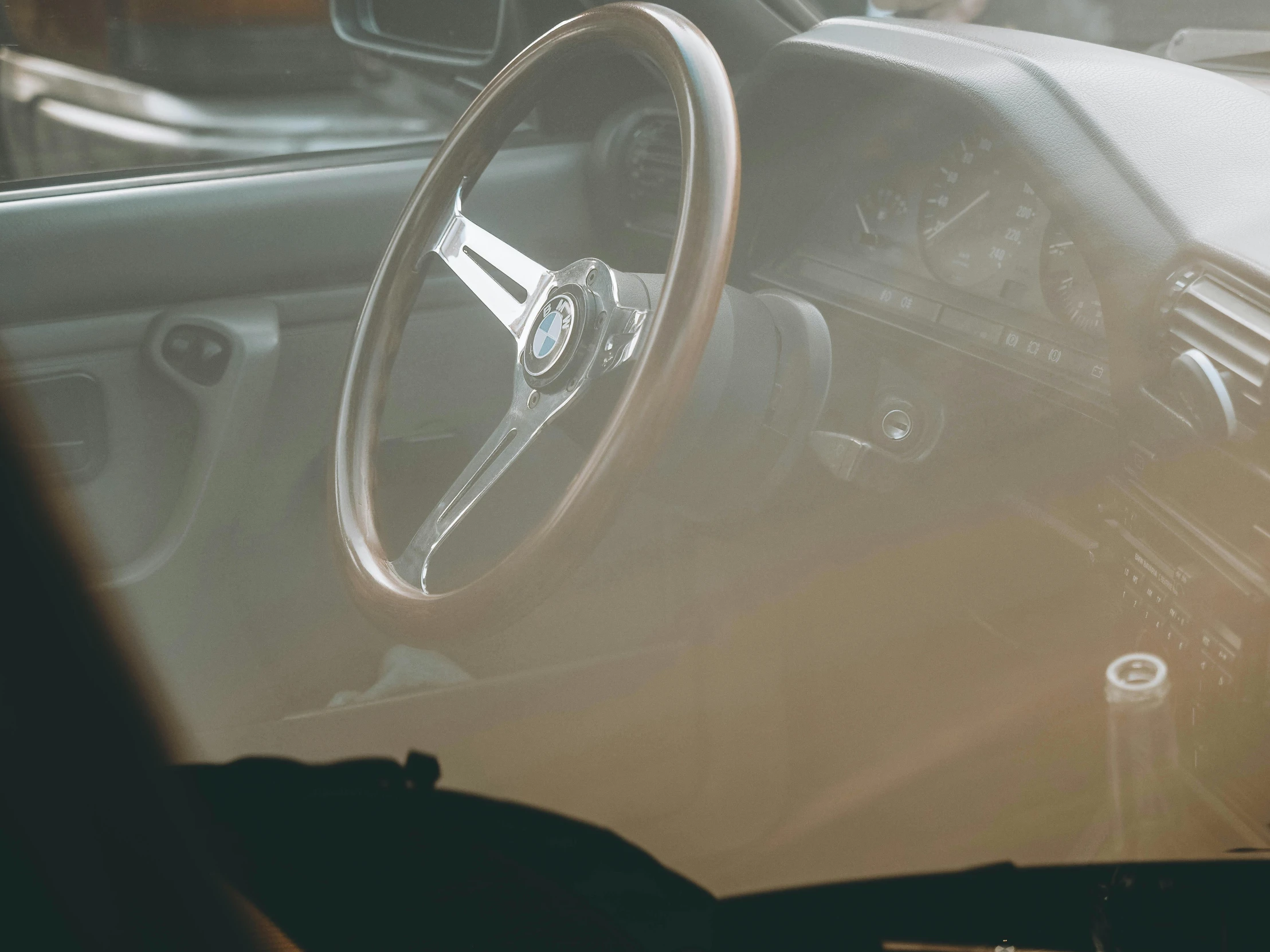 a car dashboard with an analog clock and steering wheel