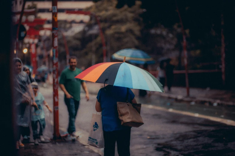 some people are walking down the street with an umbrella