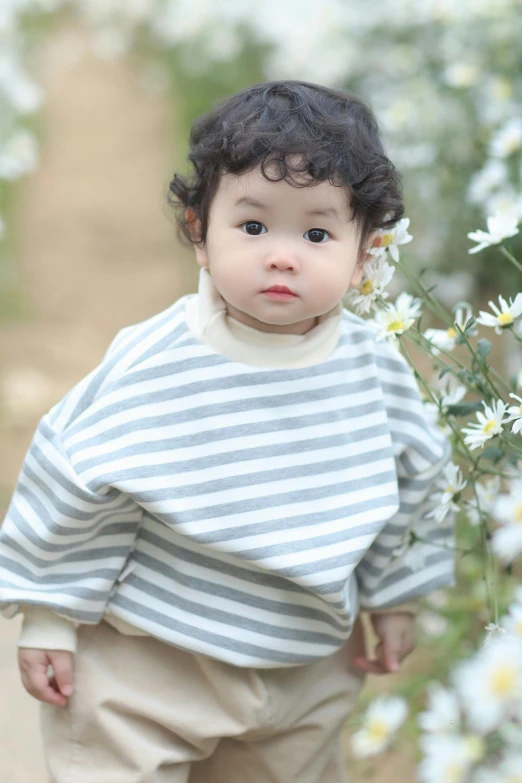 a small child is walking among white flowers