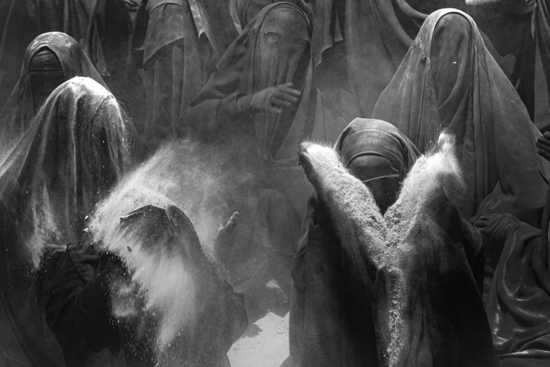people covered in dust and cloths stand together in an audience