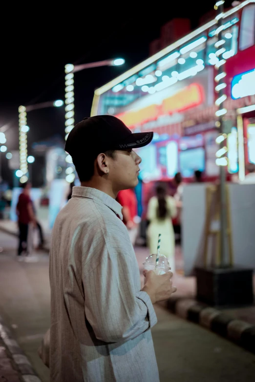 there is a man on the street drinking and walking