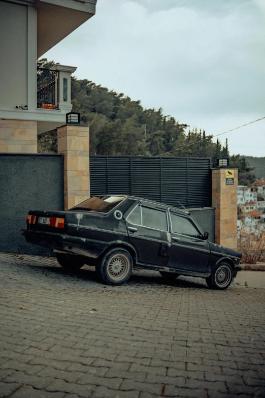 old abandoned black car parked in front of house