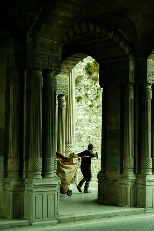 the man is walking through an archway with a bag