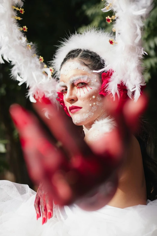 a woman in white with feathers all over her head