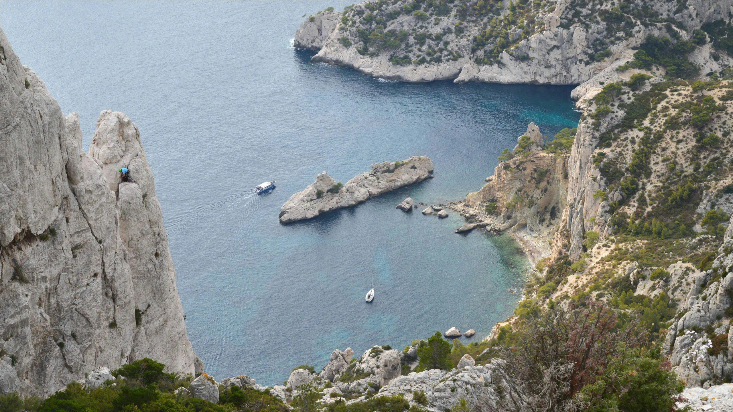 some large boats are near the rocky coast