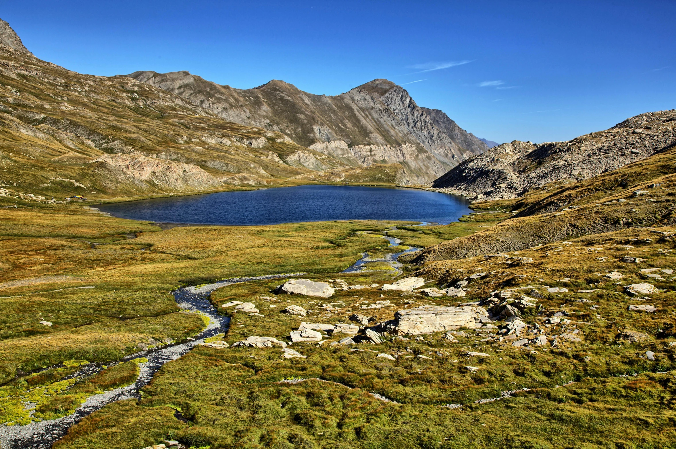 a view from the side of a mountain range at a lake