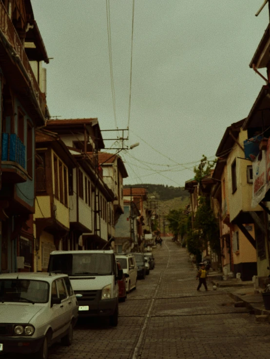 a dark street with parked cars and buildings