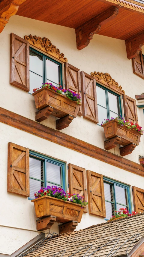 two windows with flower box balconies on top of each