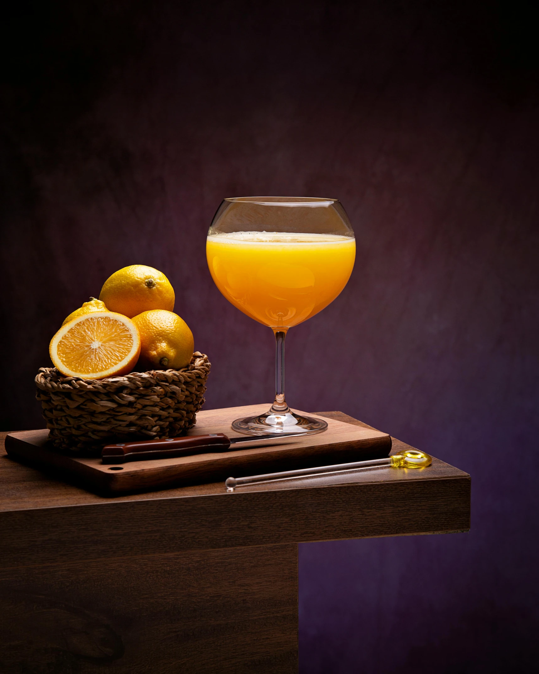 a glass and fruit sitting on top of a wooden table