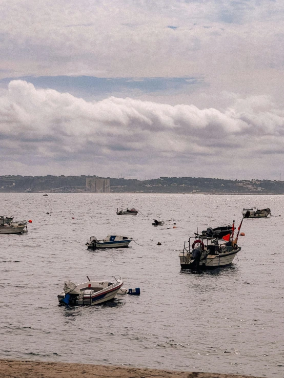 a number of small boats in the water near shore